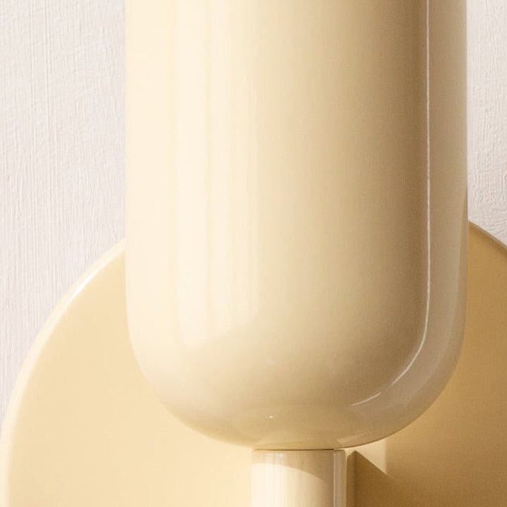 Close-up of a cylindrical product with a beige top and pink bottom on a light background