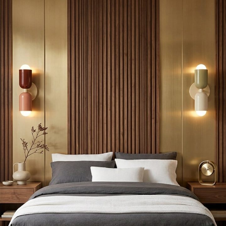 Modern bedroom with a bed, side tables, and wall sconces.
